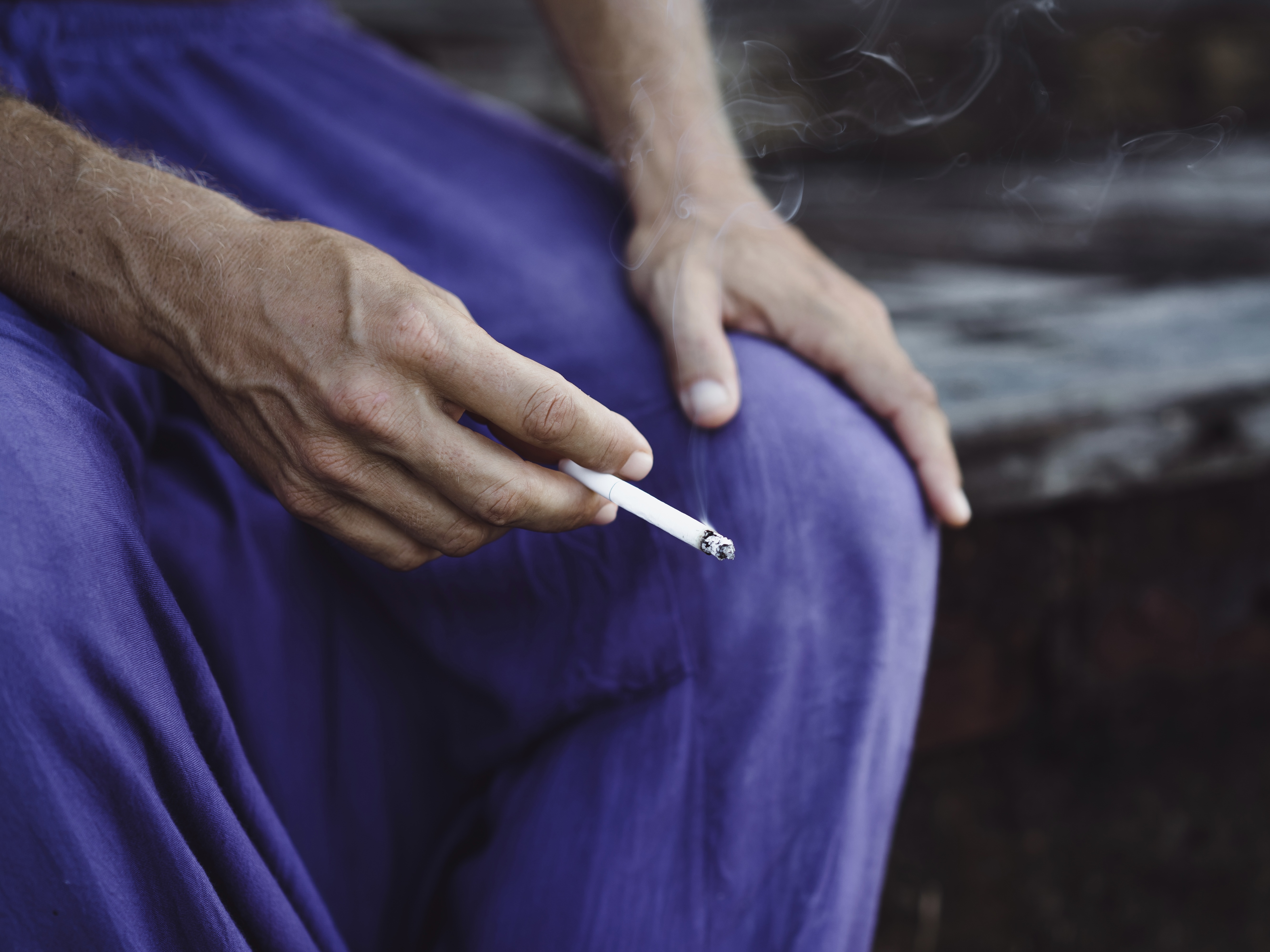 Image showing a woman holding a pack of cigarettes in one hand and covering her nose with the other, indicating discomfort from unpleasant odors. Accompanying text states that these odors can originate from various sources like cooking, pets, and tobacco smoke, cause discomfort and respiratory issues or allergies, and signify potential air quality problems such as mould